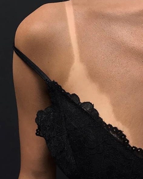 Décolleté and shoulder with a natural golden spray tan, free of orange undertones